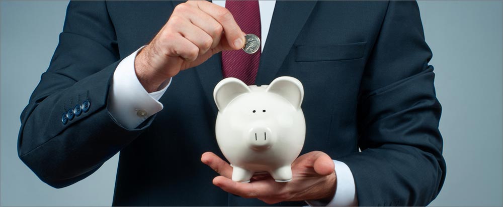man putting coins in a piggy bank