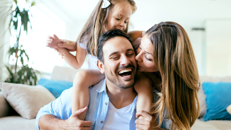 smiling woman with sunbeam looking at laptop