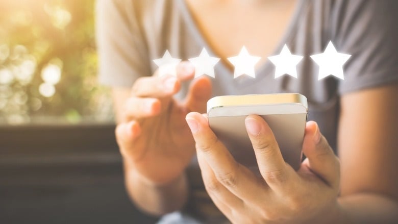 woman holding phone with 5 overlaying stars 