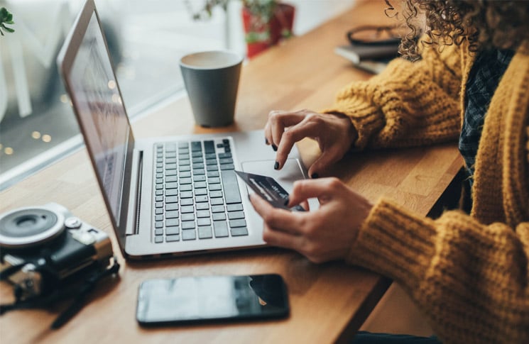 woman using credit card on laptop