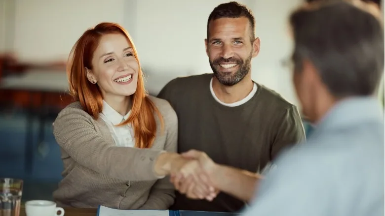 couple shaking hand of financial advisor