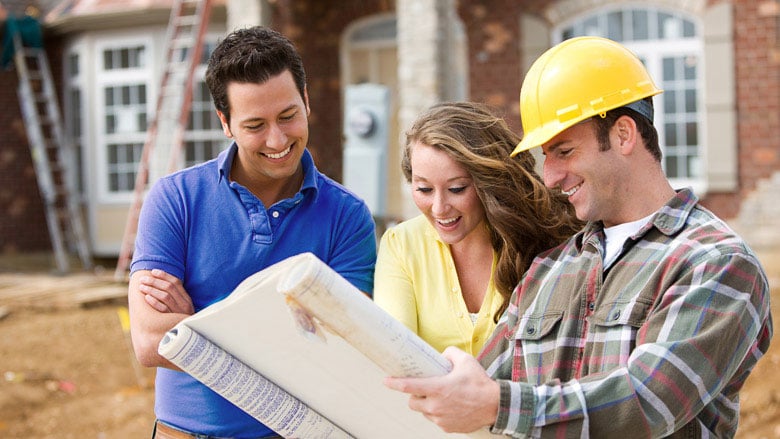 couple with contractor reviewing house plans