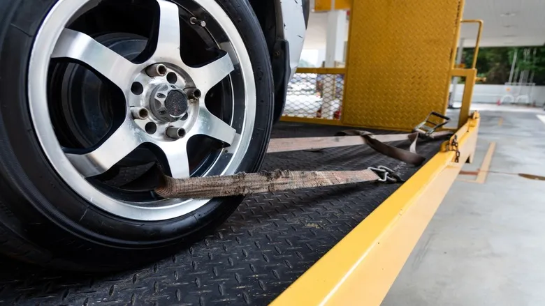 car-tied-with-security-strap-on-flatbed-tow-truck_780x439 car-tied-with-security-strap-on-flatbed-tow-truck_780x439