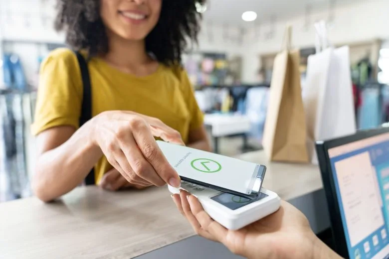 woman using mobile wallet to buy clothes