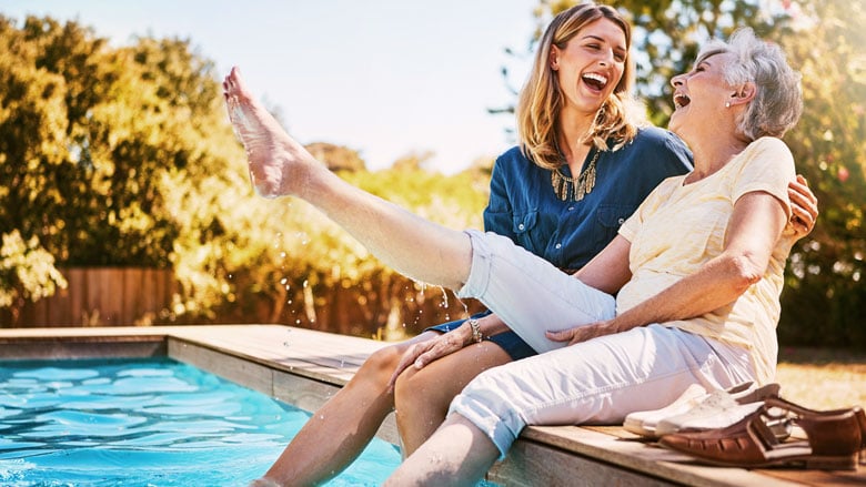 two women with their feet in a swimming pool
