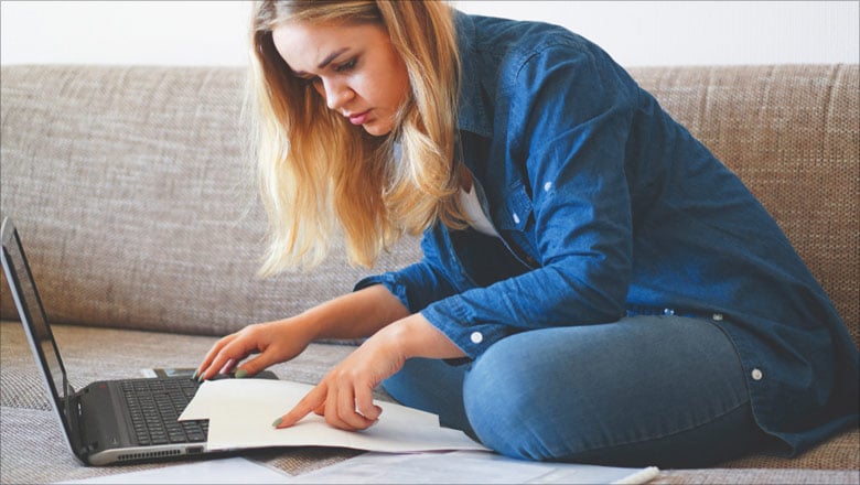 young woman with a laptop on a sofa