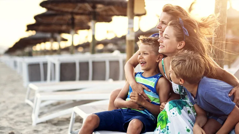 Mom with three kids in chairs on beach
