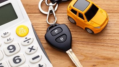 key fob with toy car and calculator on a table