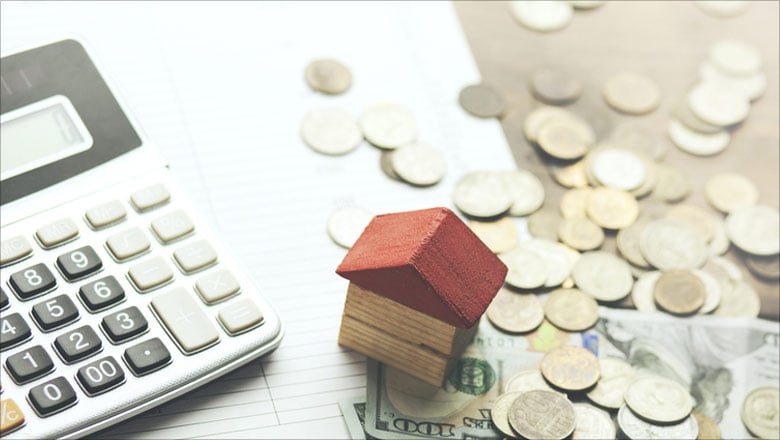 Desk with calculator, notepad, house and money on 