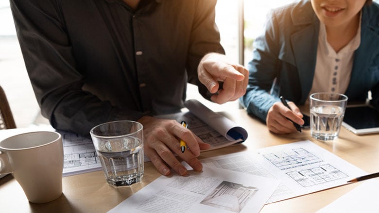 Two people reviewing construction plans