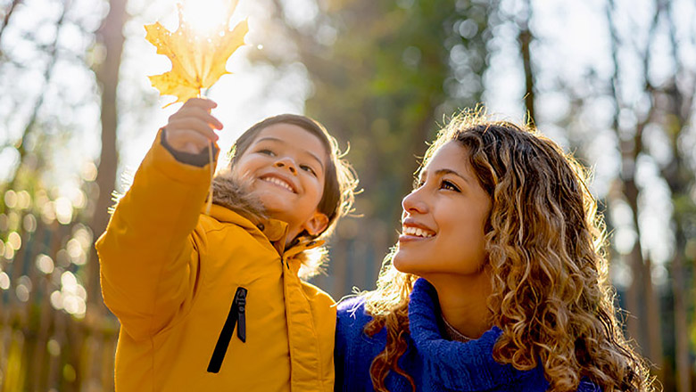 Mother and son admiring a leaf in the sunlight