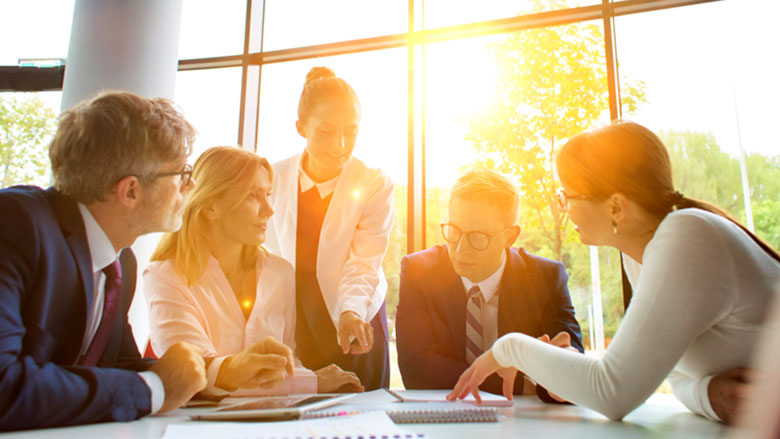People around a business table with sunglare