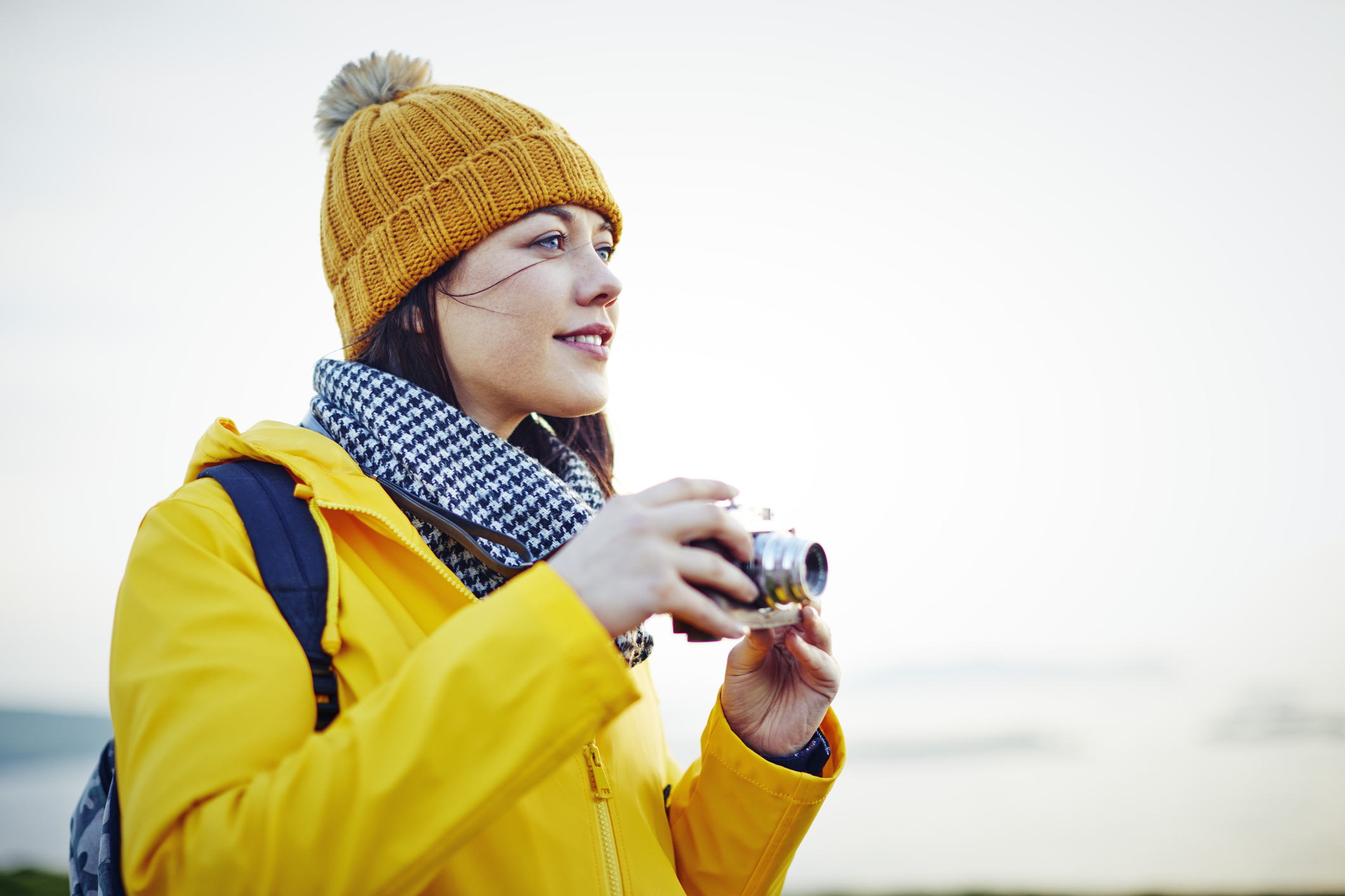 woman in coat hiking on top of mountain