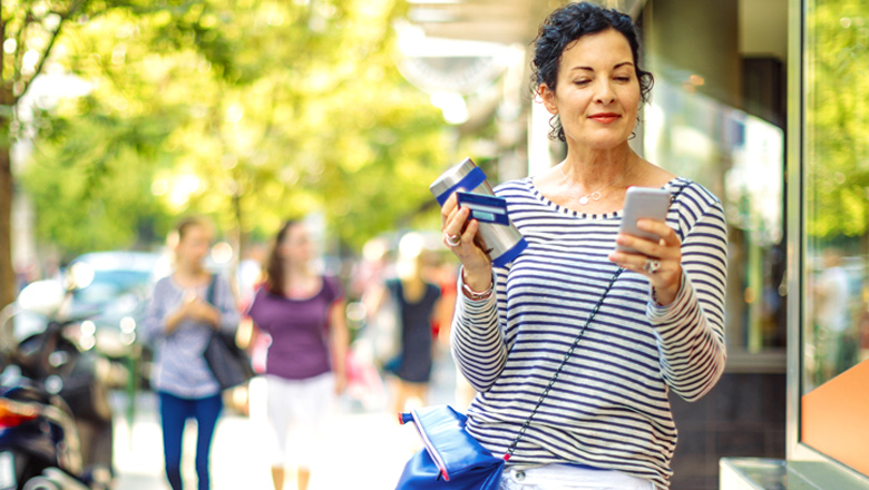 woman walking downtown using mobile banking