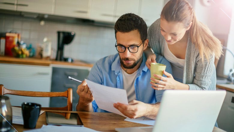 Couple at kitchen table looking at a home equity l