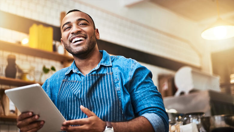 African man with tablet at his coffee shop