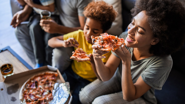 Family eating pizza while watching football