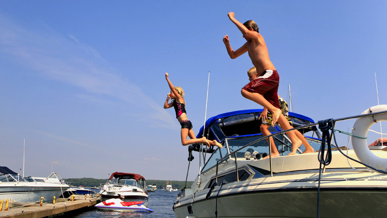 Kids jumping off boat into water