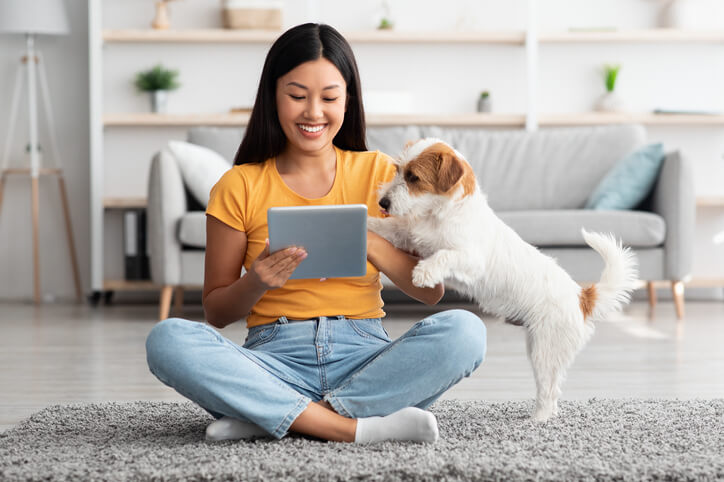happy woman with ipad and dog