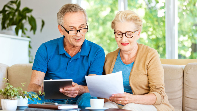 older couple on couch looking at tablet