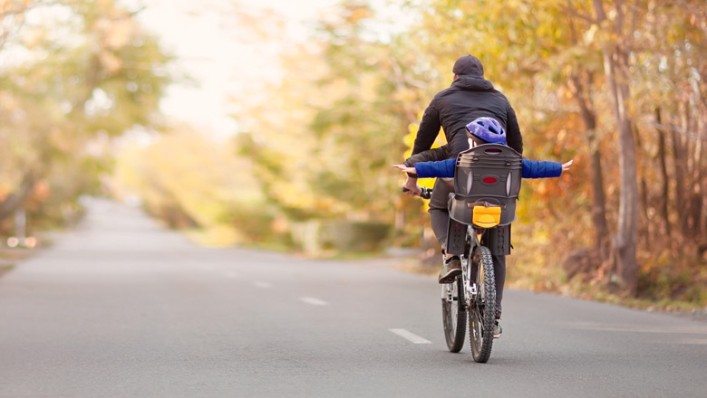 Father with son on bike pretending to fly