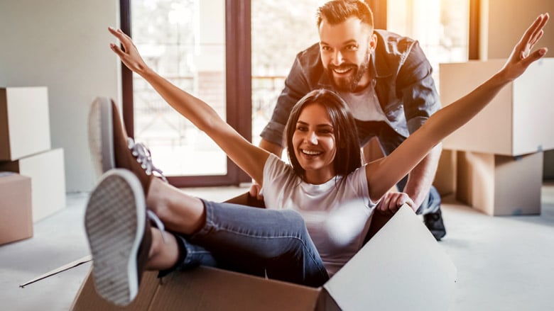 Husband pushing wife playfully in a moving box