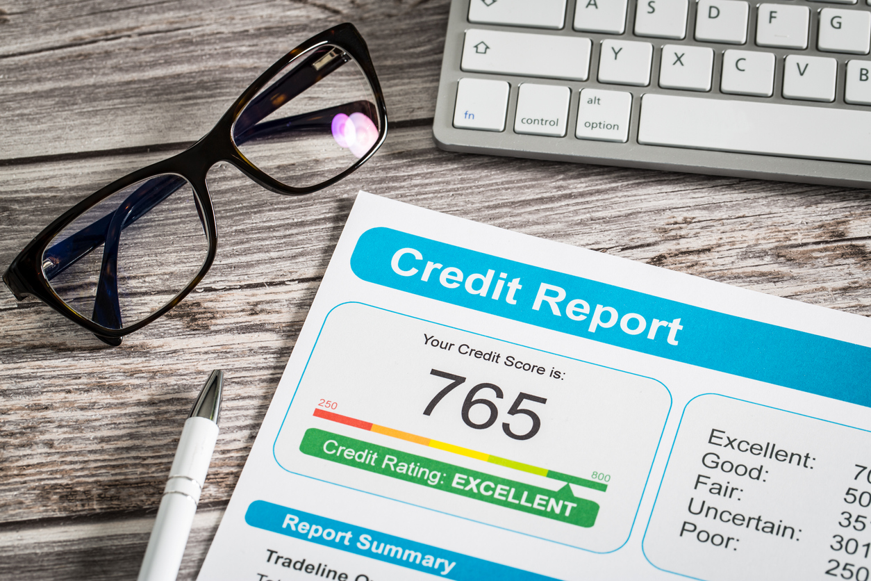 Credit report and glasses on wood surface