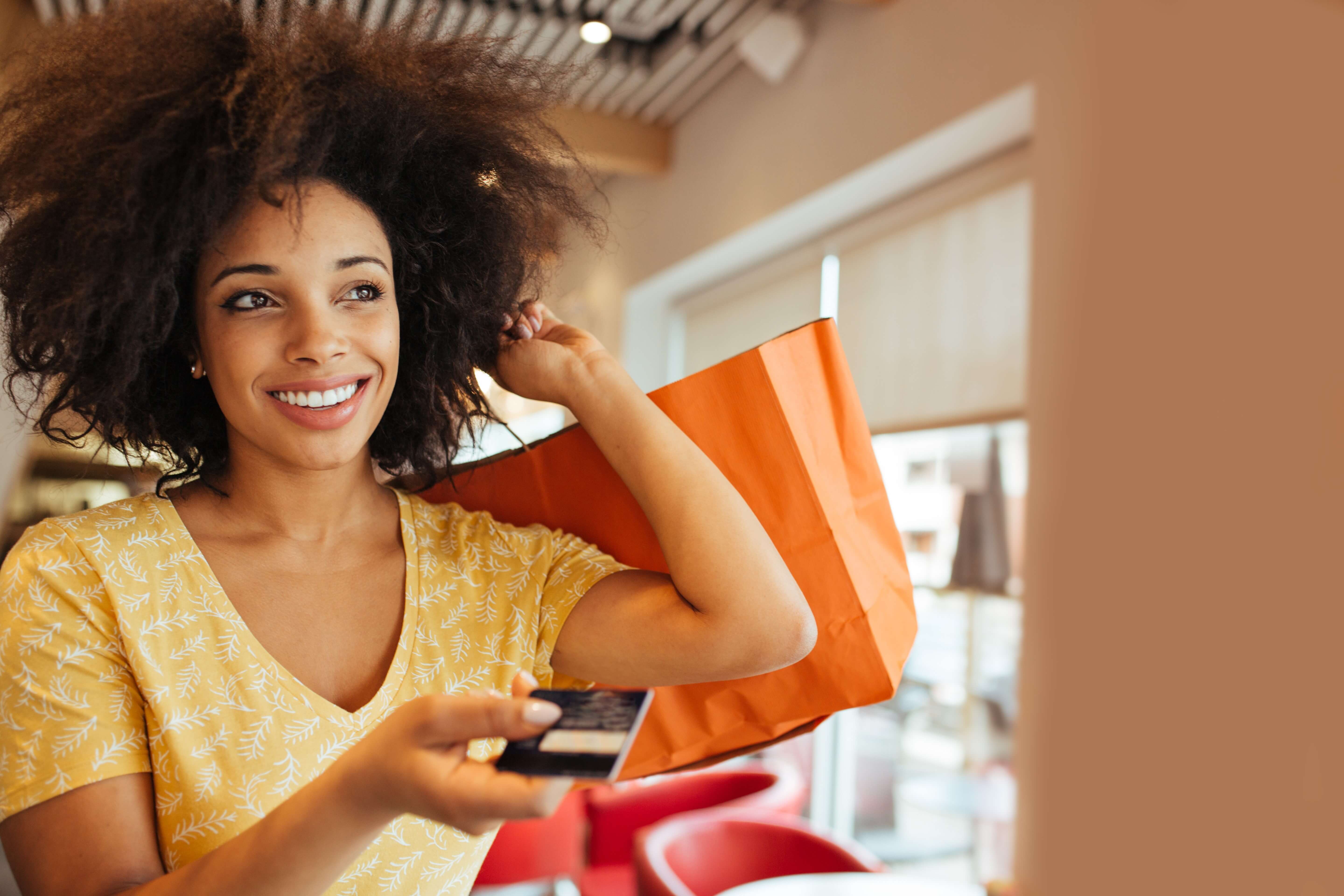 Woman with shopping bags and a Truliant debit card