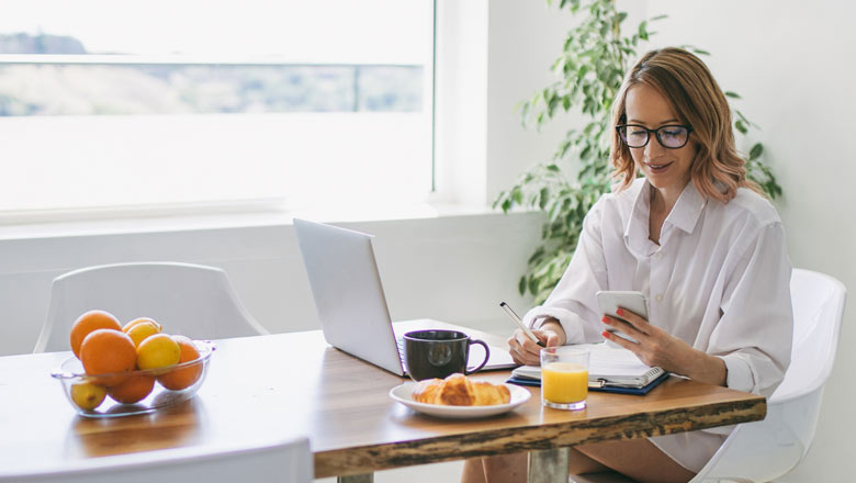 Women working on computer at kitchen table