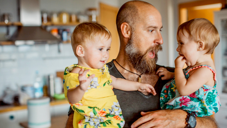dad holding toddler twin girls