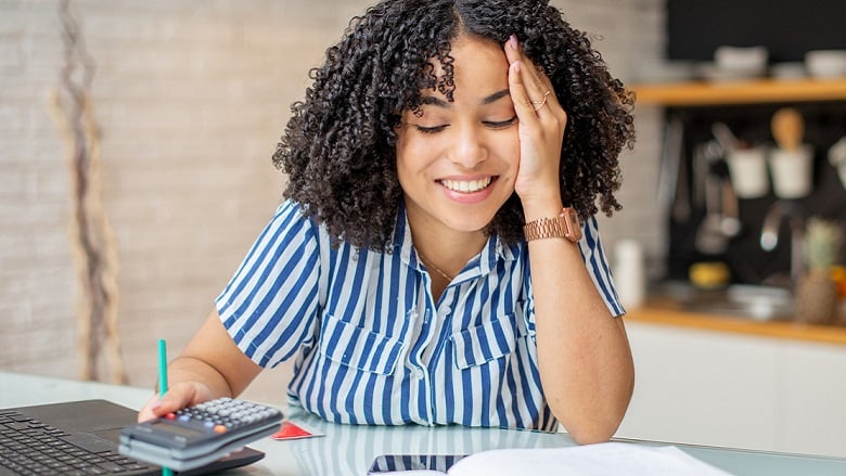 Lady at a desk with laptop and calculator