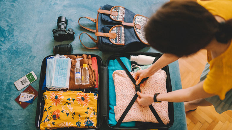 Person packing luggage for trip