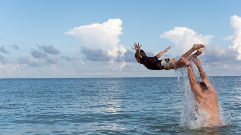 Man with son playing in the ocean