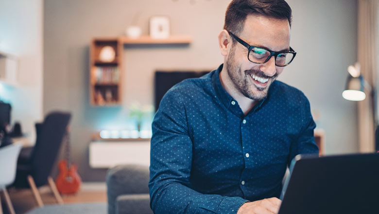 smiling man looking at laptop