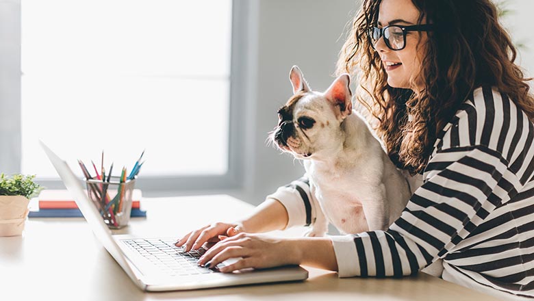 Lady with her dog at a laptop