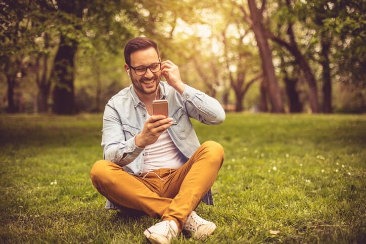 Man on his headphones and phone in a park